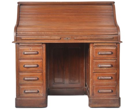 An early 20th Century mahogany twin pedestal roll top desk. The tambour front top opening to reveal an arrangement of small d