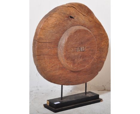 An Antique carved wooden rustic cart wheel displayed upon an ebonised stepped plinth base. Measures approx; 70cm x 61cm diame