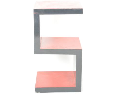A contemporary retro inspired side table / lamp table / display shelves of S-shaped form forming the shelves. Black lacquered