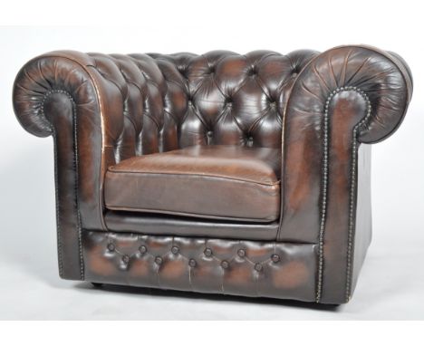 Thomas Lloyd - A contemporary brown leather button backed Chesterfield Club fireside armchair having scrolled back and armres