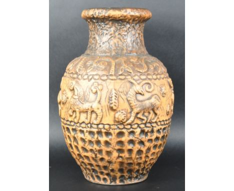 A large retro 20th Century German studio art pottery vase of bulbous form decorated in relief with mythical creatures, foliag