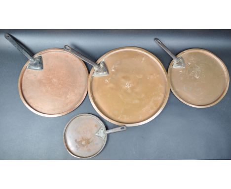 A graduating set of four 19th Century Victorian copper saucepan lids / pans. Each of circular form and having cast iron handl