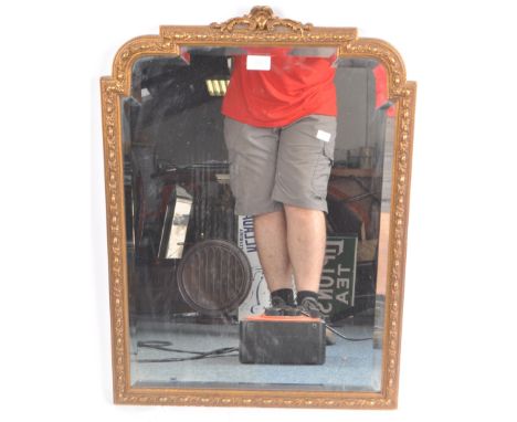 A vintage 20th Century Hollywood Regency gilt framed overmantle mirror having a bevelled edge mirror plate having an arched t