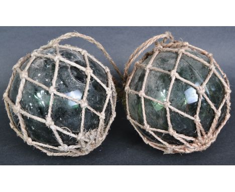 A pair of early 20th Century pressed green glass&nbsp;witches balls with each hanging via rope nets. Each measures approx; 14