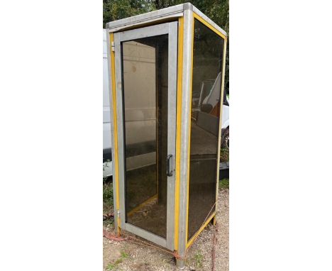 A late 20th Century 1980s / 90s American military telephone box / cubicle having a full length glazed door and side with soli