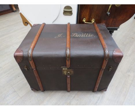 A featherweight Flaxite fibre travel trunk with bentwood/metal strapping and brass studding, having a lined interior with lea