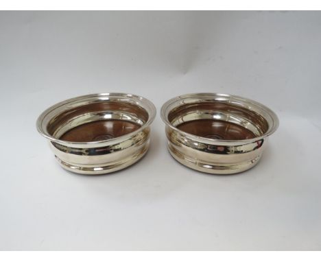 A pair of Garrard and Co Britannia Standard silver wine coasters, London 1977, 14.5cm diameter