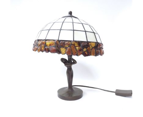 From the Southwold Amber Museum, a decorative table lamp with opaque white shade with amber set border over an Art Nouveau ca