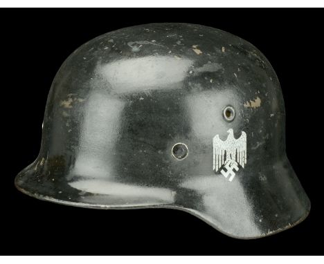 A Second War German M35 steel helmet. A Second War German M35 steel helmet, repainted in black with Wehrmacht decals, stamped