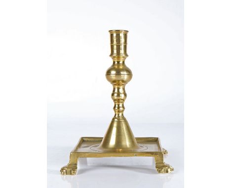 A brass tray-base candlestick, Spanish, circa 1700Having a cylindrical socket with mid-fillet, and a ball-knopped stem atop a