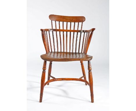 A George III fruitwood and elm comb-back Windsor armchair, circa 1800

The low back with nine spindles supporting a round-end