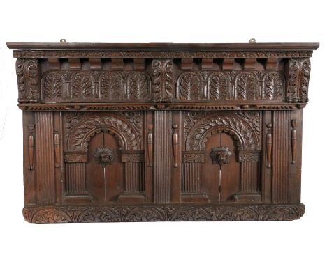 An Elizabeth I oak overmantle/headboard, West Country, circa 1590With leafy-carved cornice and dentil frieze, atop a stiff-le