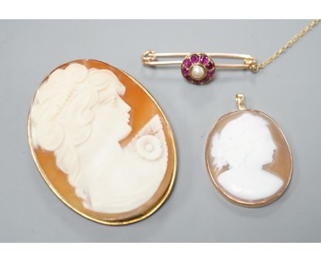 A 9ct mounted oval cameo shell pendant, 36mm, a similar gilt white metal mounted brooch and a yellow metal, ruby and cultured