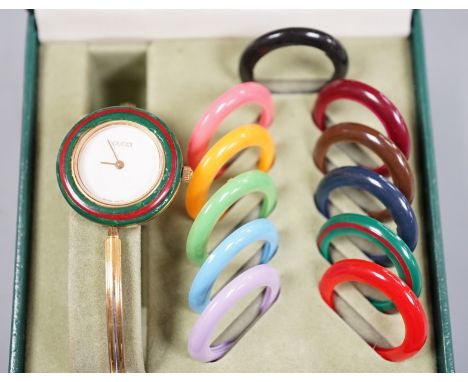 A lady's modern Gucci bangle wristwatch wit interchangeable bezels, with box and some paperwork.