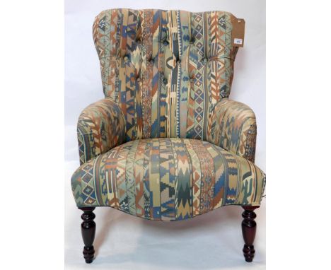 A wingback armchair with button back geometric upholstery, raised on turned legs 
