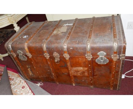 An early 20th century, large, Greek, leather-bound, wooden trunk with exterior wooden strip detailing, leather side handles, 