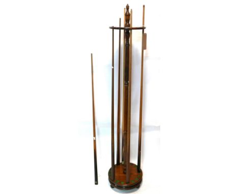 Six vintage snooker ques together with 6 black enamelled carry cases and an oak stand 