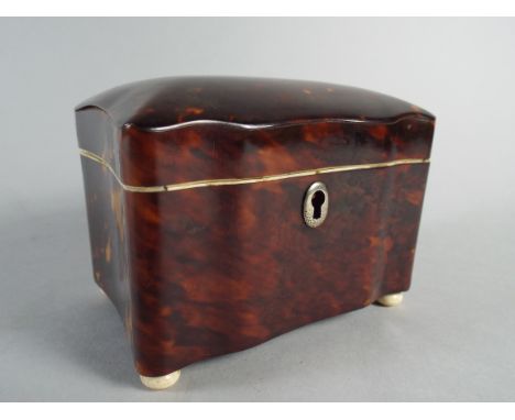 A 19th Century Tortoiseshell Tea Caddy with a Domed Top over Ogee Shaped Sides, Supported on Ivory Feet. The Interior with a 