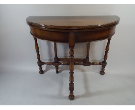 A 1920s Oak Demi Lune Lift Top Games Table with Beize Playing Surface, Turned Supports and Stretchers. 