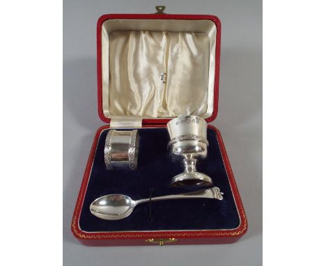 A Cased Silver Set Comprising Egg Cup, Tea Spoon and Napkin Ring. Birmingham 1952 by The Adie Brothers. Retailed By Finnigans