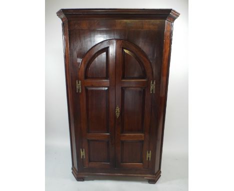 A Good Georgian Mahogany Corner Cabinet with Arched Panelled Doors with Brass H Hinges to Shaped Shelf Interior. 91cm Wide, 1