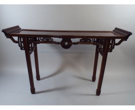 A Good Chinese Padouk Wood Side Table with Carved and Pierced Mouldings and Scroll Ends. 134x39x87cm High 