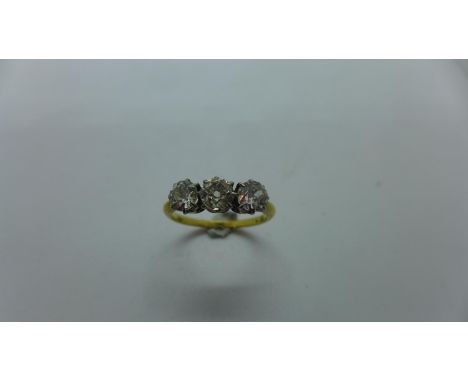 An 18ct yellow gold three stone diamond ring, claw set with three old mine brilliant diamonds in individual clawed side by si