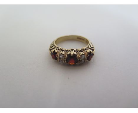 A hallmarked 9ct gold ring set with three large garnet colour stones ad four white stones, ring size K, approx 4 grams, gener