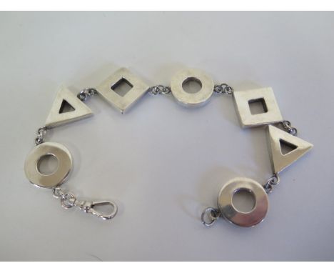 An abstract silver bracelet made up of alternate triangular and circular links with pierced decoration to one side 