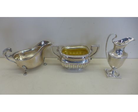 A silver twin handled sugar bowl, Birmingham 1902 - a silver cream jug Chester 1906 - and a silver sauce boat, with lion hand