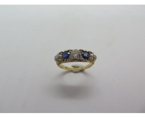 An 18ct hallmarked diamond and sapphire five stone ring, size K/L, approx 4.1 grams, centre diamond approx 0.45ct 