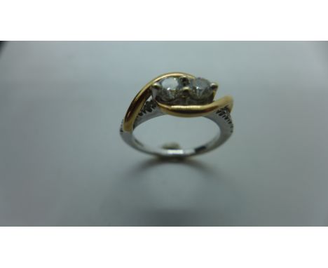 A 14ct white and rose gold cross over diamond ring set with two diamonds, each approx 0.2cts with small diamonds to the shoul