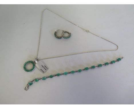 A silver pendant set with emeralds, a pair of silver emerald earrings ans a similar bracelet 