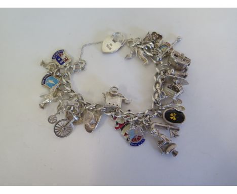 A silver charm bracelet with various silver and white metal charms, approx 65 grams 