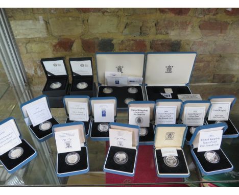 Eighteen silver proof pound coins and a collection box, 1986 to 1992, 1994,1996 to 2003 and two 2008 