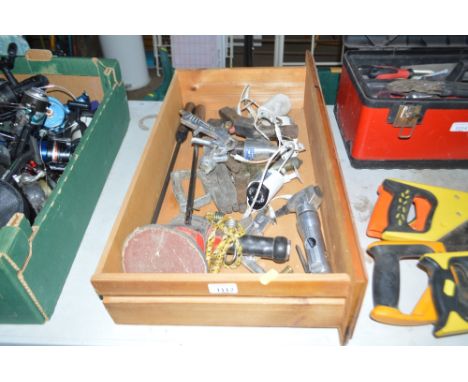 A wooden drawer containing air tools