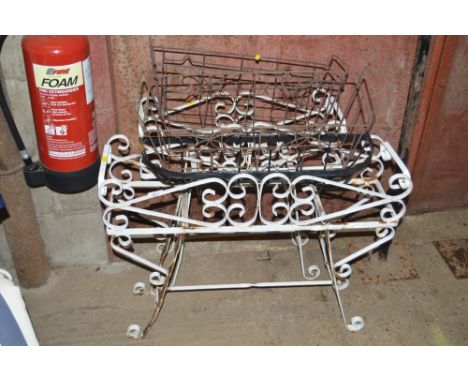 A pair of wrought iron planters; two wire work baskets; and one other planter