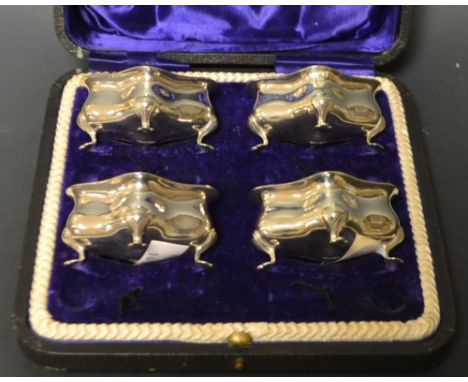 A set of four Edwardian silver quatrefoil table salts, each resting on four cabriole legs, Sheffield 1907, csed