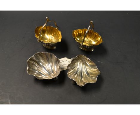 A pair of Victorian silver scallop shell shaped table salts, each resting on three globular feet, Sheffield 1897; a pair of s