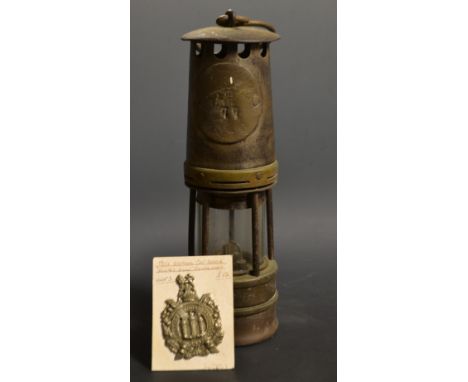 A miner's lamp; a cap badge, 1902 King's Own (2)