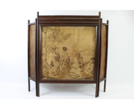 A folding firescreen carved with japonaiserie flowering grasses, the central panel with a woven textile panel of Japanese fig