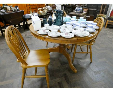 A circular modern pine single pillar dining table tougher with three wheel back Windsor chairs 