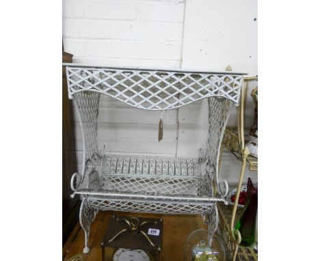 A cream painted decorative metal plant table with trough under 