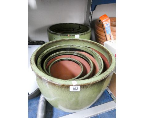 Two sets of four graduating circular glazed ceramic pots 