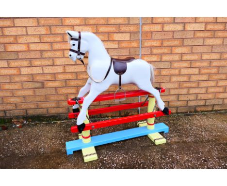 An unmarked children's rocking horse which measures approximately 90cms (H) x 92cms (L) x 36cms (D). The horse is missing a s