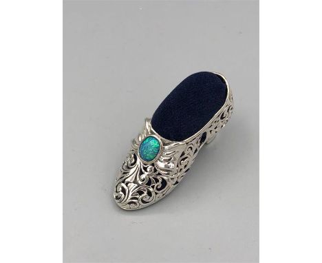 A substantial silver pin cushion in the form of a shoe inset with opal.