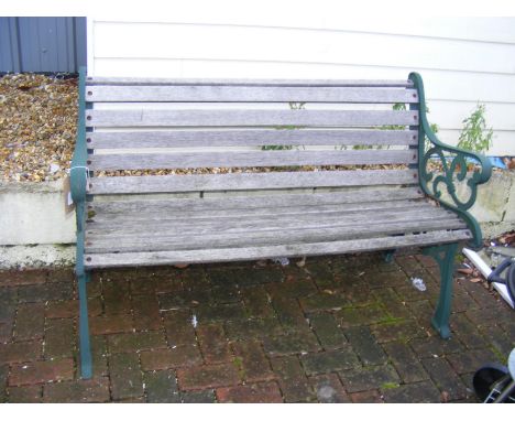 A slatted wooden bench with cast iron ends - length 129cm
