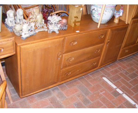 A mid century Ercol Golden Dawn sideboard with central three drawer section, flanked by cupboards - width 156cm