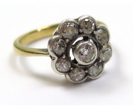 Yellow metal (tested as 18ct) ladies ring, central diamond surrounded by eight further diamonds, weight 3.7g.