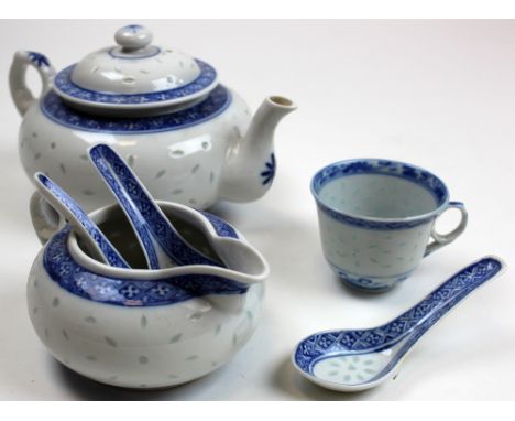 An underglaze blue decorated Chinese Porcelain Teapot of squat form and matching milk jug. Rice pattern throughout, together 